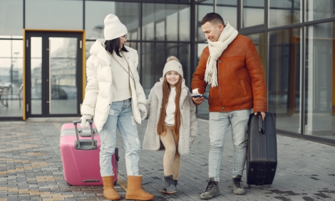 family stand airport with luggage